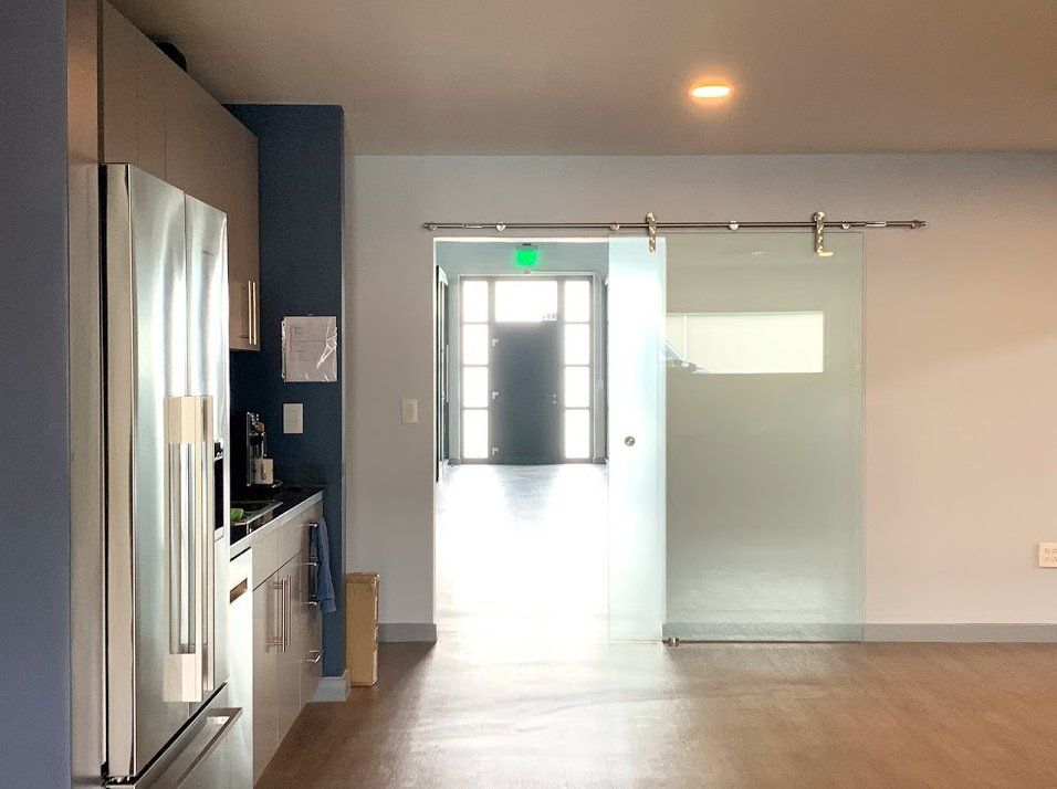 A kitchen with a refrigerator and a sliding glass door