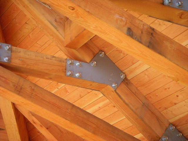 A close up of a wooden roof with metal beams