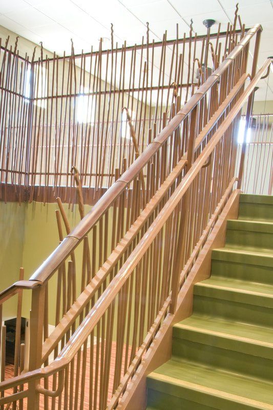 A staircase with a wooden railing and green steps