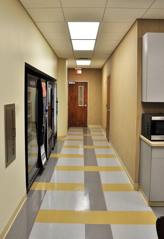 A long hallway with a vending machine and a microwave