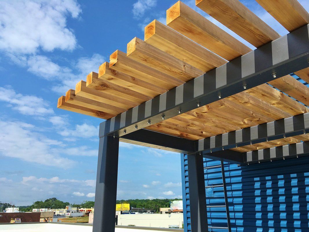 A wooden pergola is being built on top of a blue building.