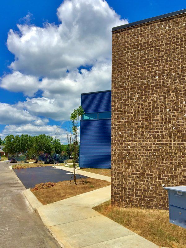 A brick building with a blue building in the background