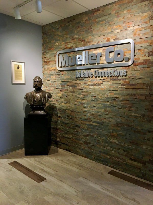 A lobby with a statue and a sign that says mueller co.