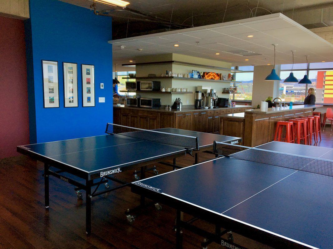 A room with two ping pong tables in it