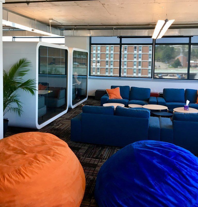 A living room with blue couch and orange bean bag chairs
