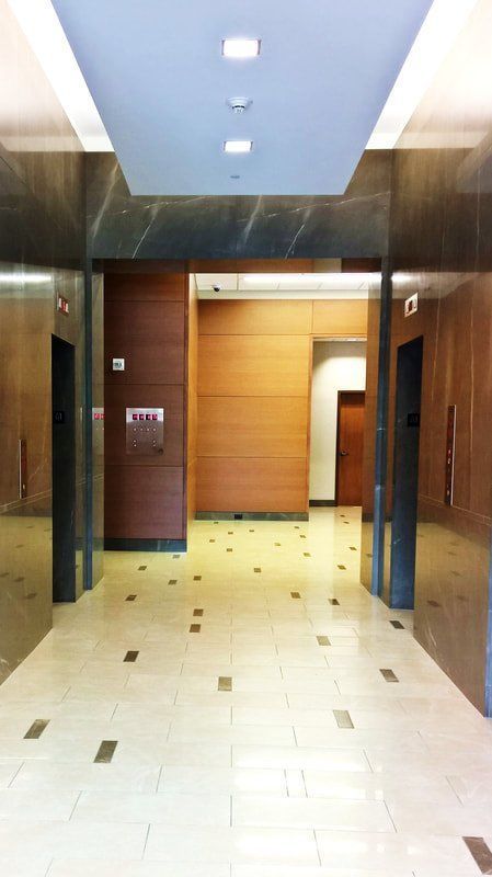 A hallway with two elevators and a sign that says exit