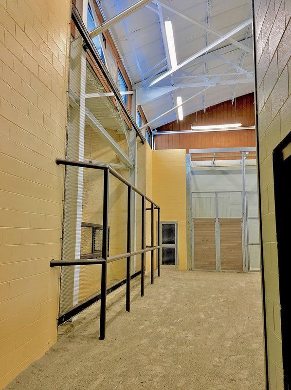 An empty hallway with a brick wall and a metal railing