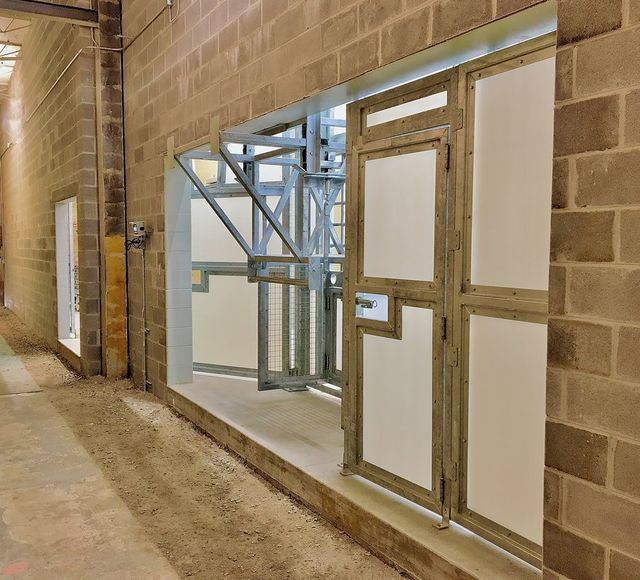 A hallway with brick walls and white doors