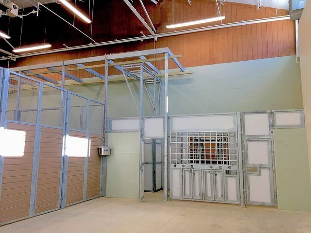 A large empty room with a fence and doors