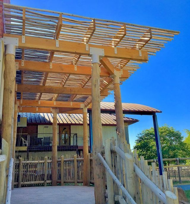 A wooden pergola with a blue sky in the background