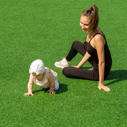 A baby enjoying an artificial grass lawns in a Colchester garden