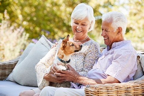 Happy Senior Couple Sitting with a Pet Dog — KS & MO — Leary & Associates Happy Senior Couple Sitting with a Pet Dog — KS & MO — Leary & Associates
