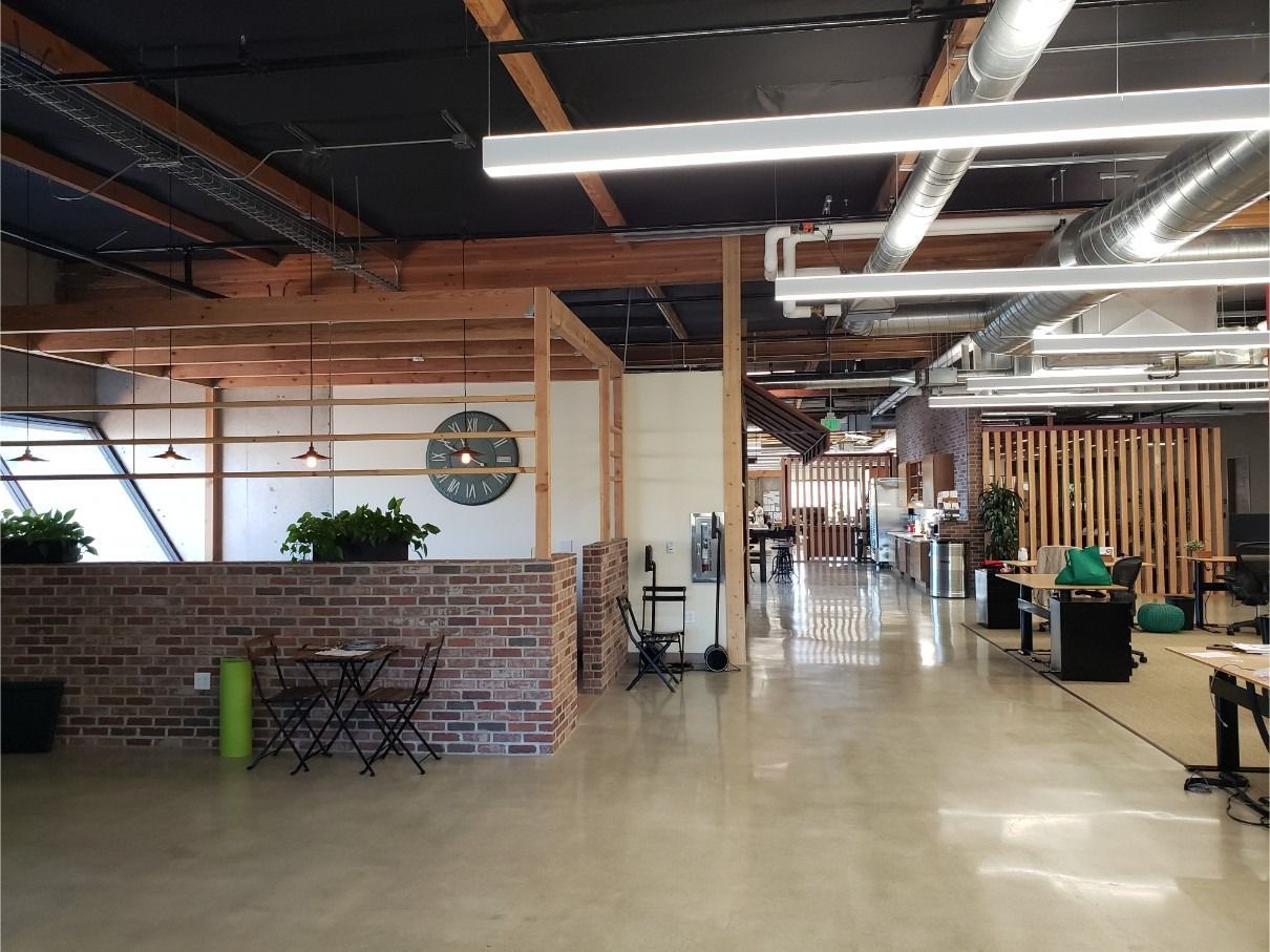 A large open office space with lots of desks and chairs.