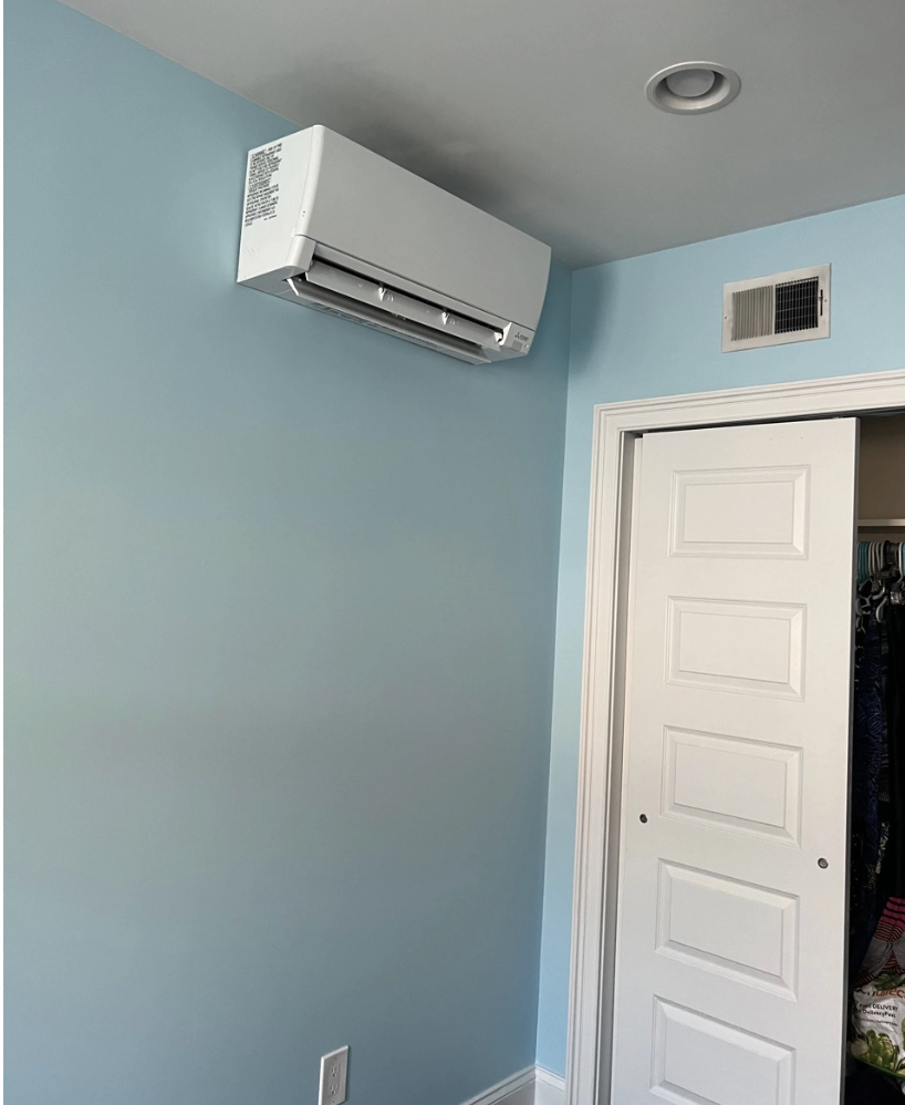Blue room with a wall-mounted white air conditioner above a doorway.