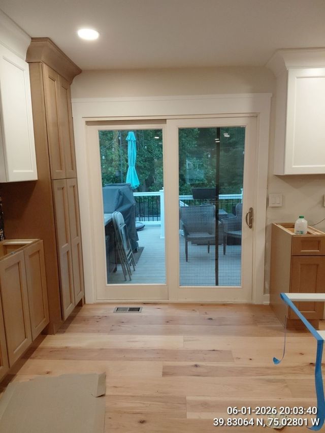 Wooden kitchen with sliding glass doors opening to a patio and trees outside