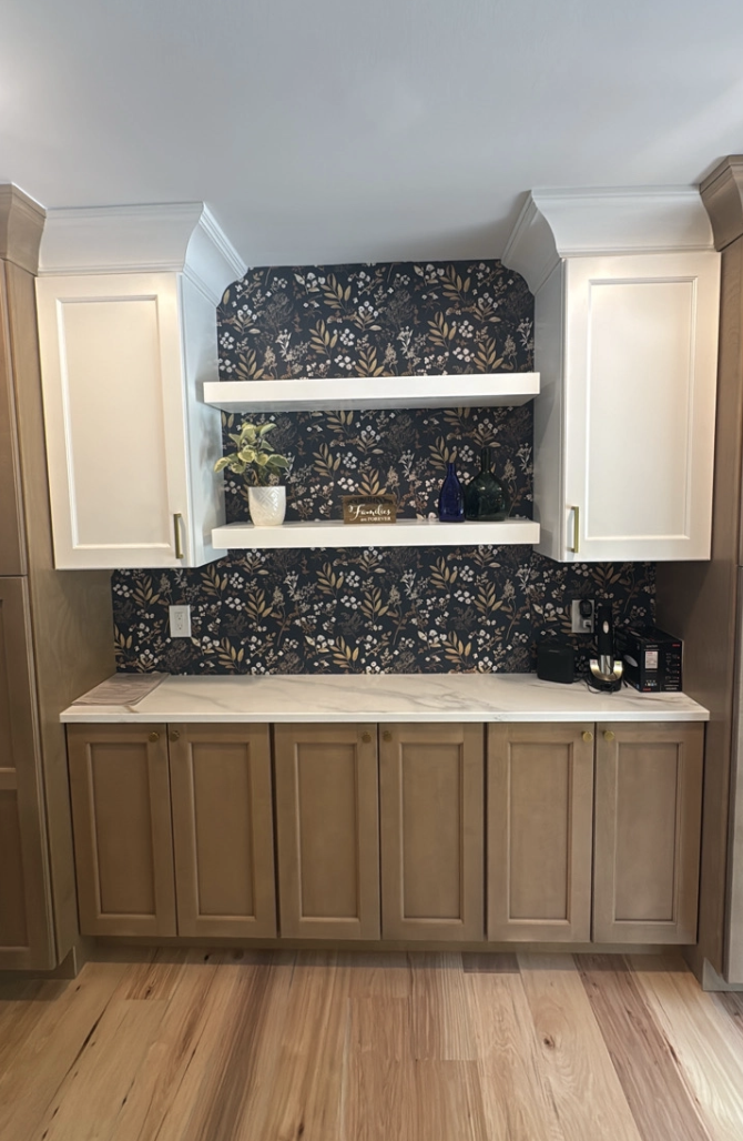 Kitchen with light wood cabinets, white countertops, and blue patterned backsplash above open shelves.
