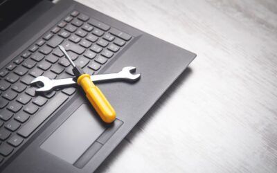 Una tastiera di laptop con una chiave inglese e un cacciavite giallo sopra, a suggerire una riparazione del dispositivo.
