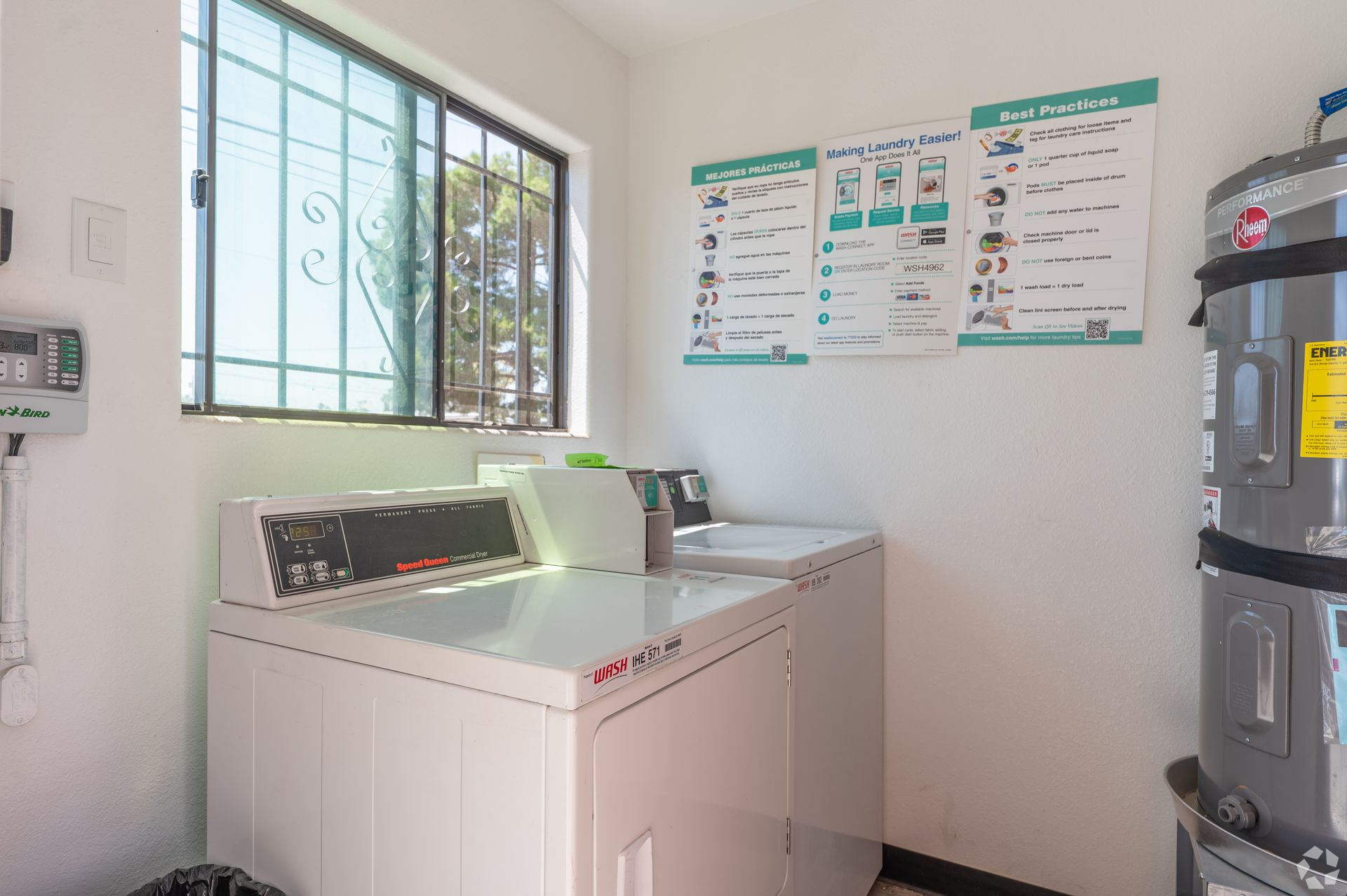 Laundry room with washer, dryer, window, and wall-mounted instructions
