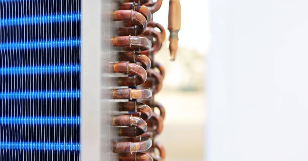 A large indoor heat exchanger with copper coils and aluminum, dual-tone blue fins in light and dark shades.