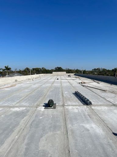 Flat white rooftop with construction materials under a clear blue sky