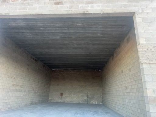 Empty concrete storage bay with a high ceiling and block walls