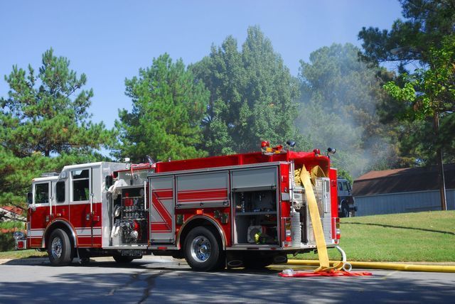 Red Fire Truck Point Location With Person Inside Of Inside Three People With Star Fire Extinguisher — Cincinnati, OH — Kramer & Associates Fire and EMS Consulting