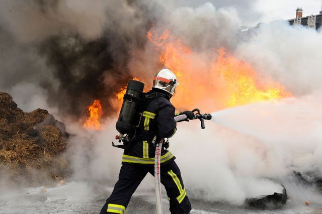 Fire Fighter Risking Their Life Doing The Job To kill The Fire Point Location With Person Inside Of Inside Three People With Star Fire Extinguisher — Cincinnati, OH — Kramer & Associates Fire and EMS Consulting
