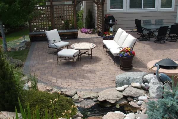 Patio with seating, pond, and garden with a gazebo and dining area.