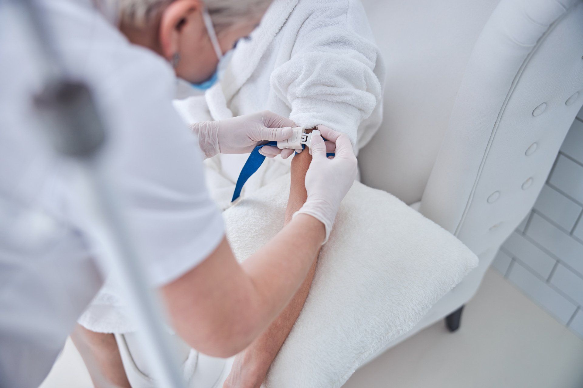 Arm wird mit Stauschlauch vorbereitet für eine Infusion