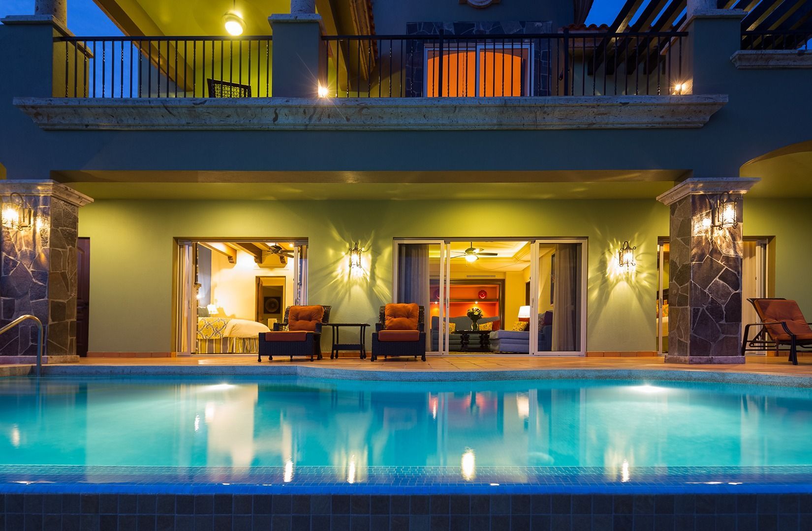 Luxury villa at dusk with a glowing pool and lit terrace