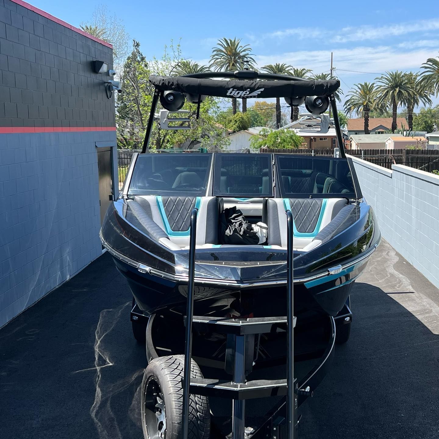 A boat is parked on the side of the road on a trailer.