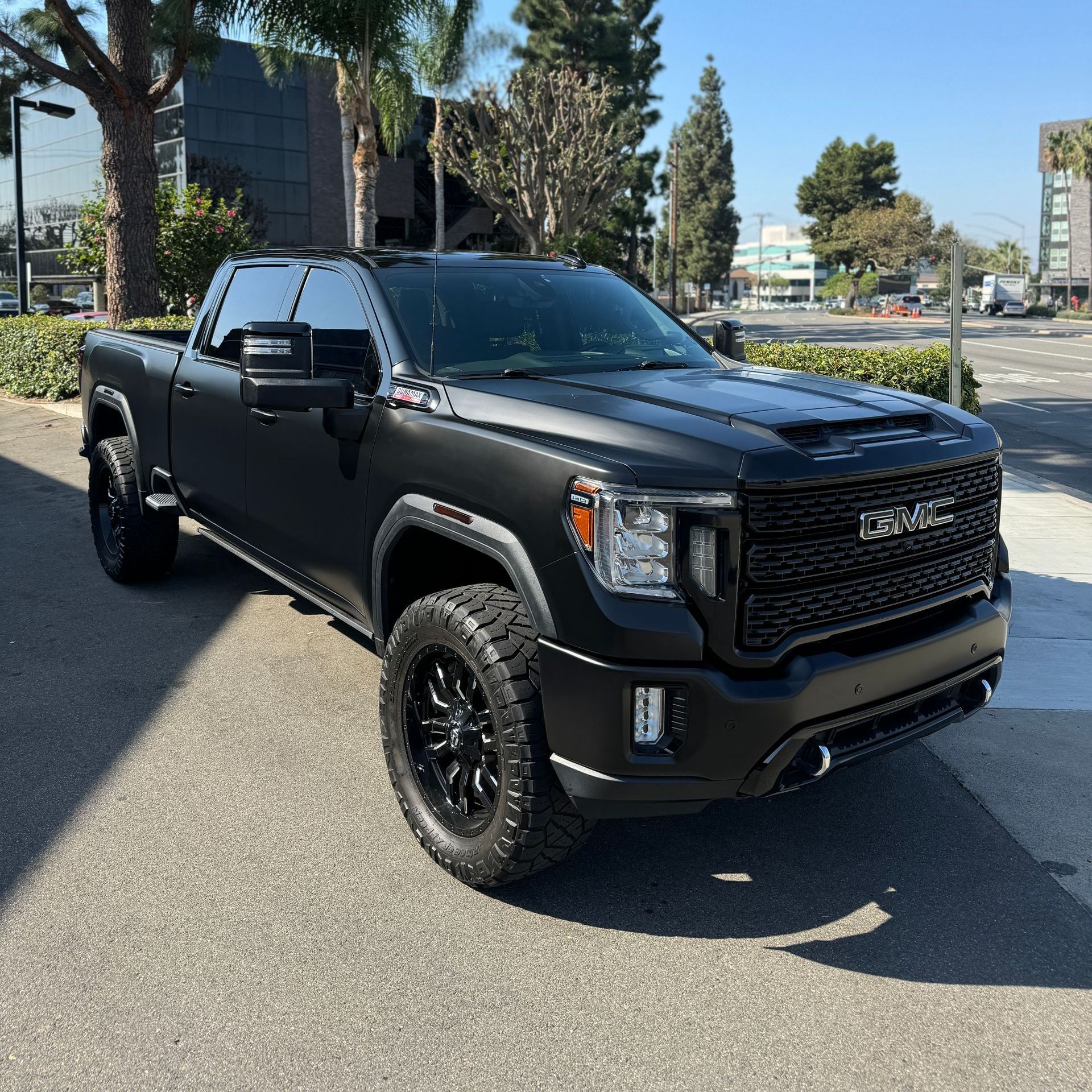 A black truck is parked on the side of the road.