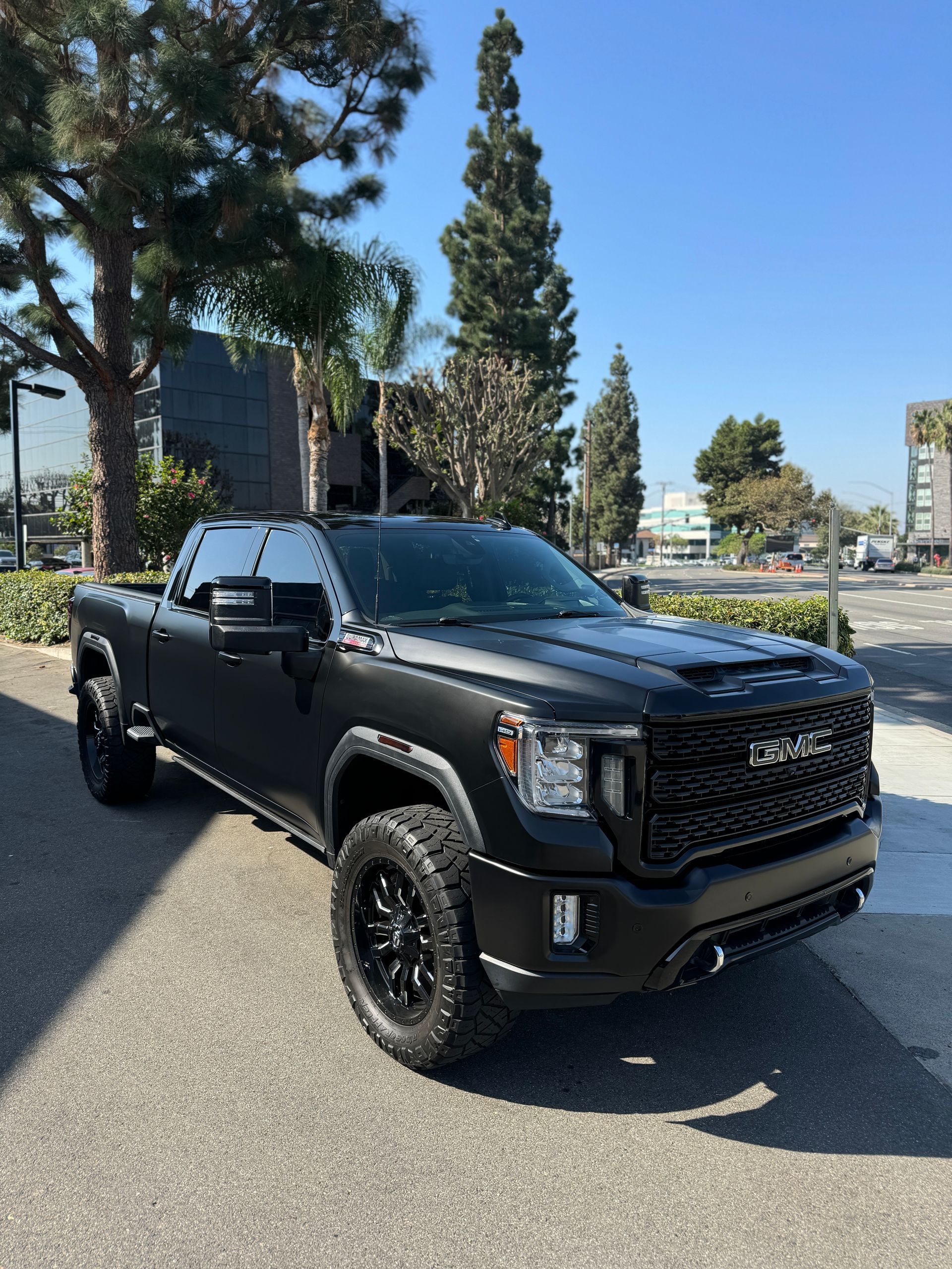 Gray lifted Ford pickup in an auto shop with tinting equipment