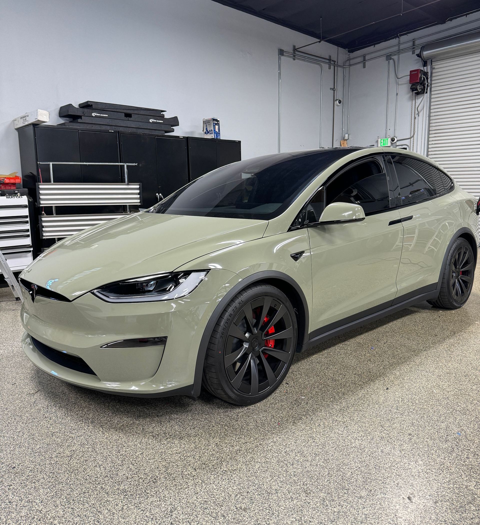 A tesla model x is parked in a garage.