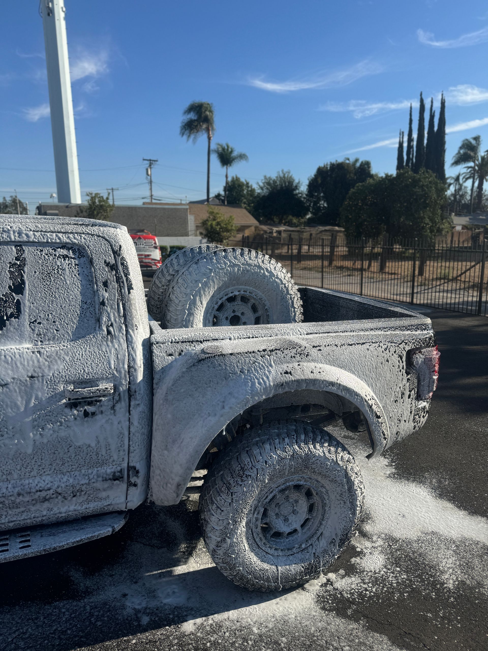 A truck is covered in foam in a parking lot