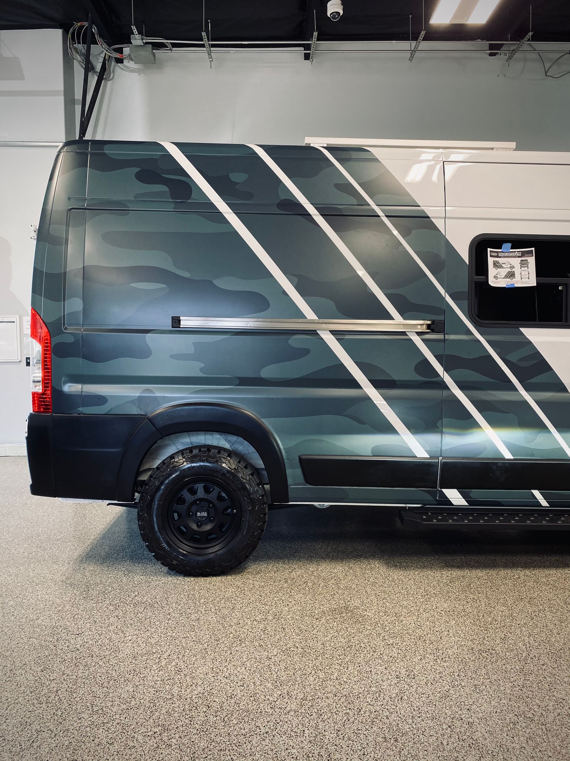 Gray lifted Ford pickup in an auto shop with tinting equipment