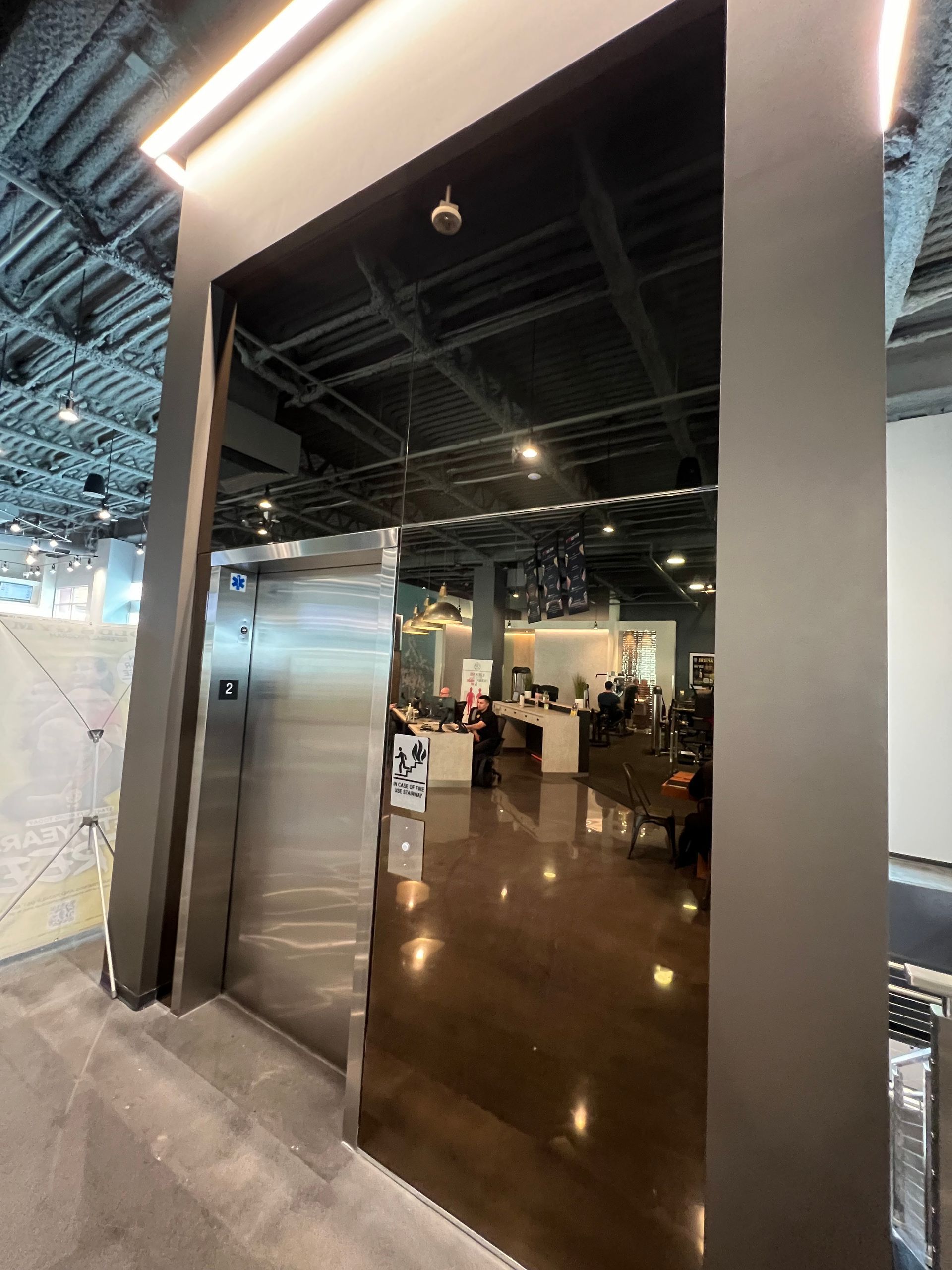 A stainless steel door is open to a large room in a building.