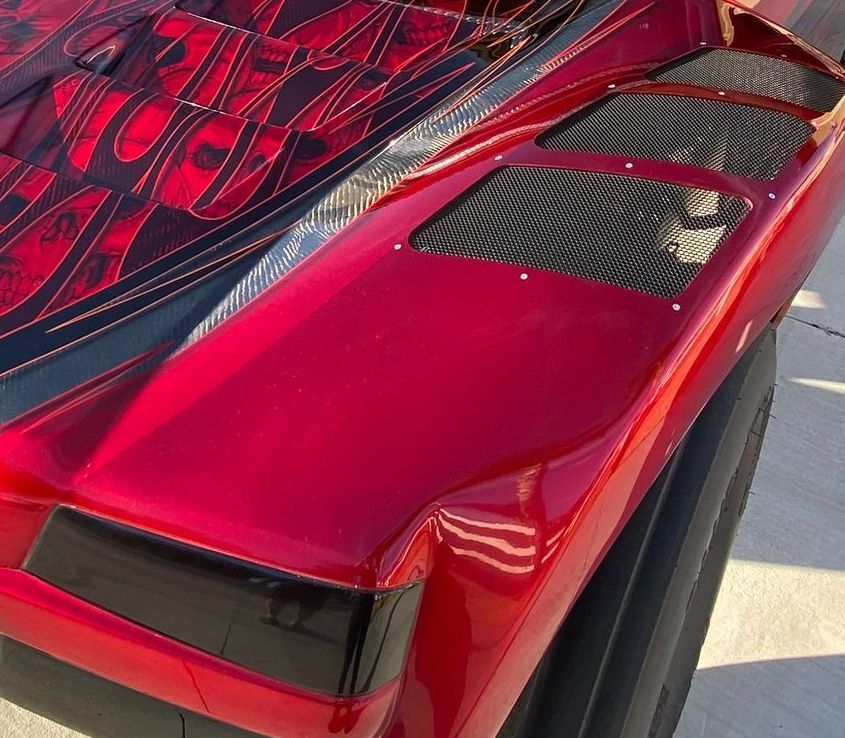 Red custom vehicle with black accents and patterned design.