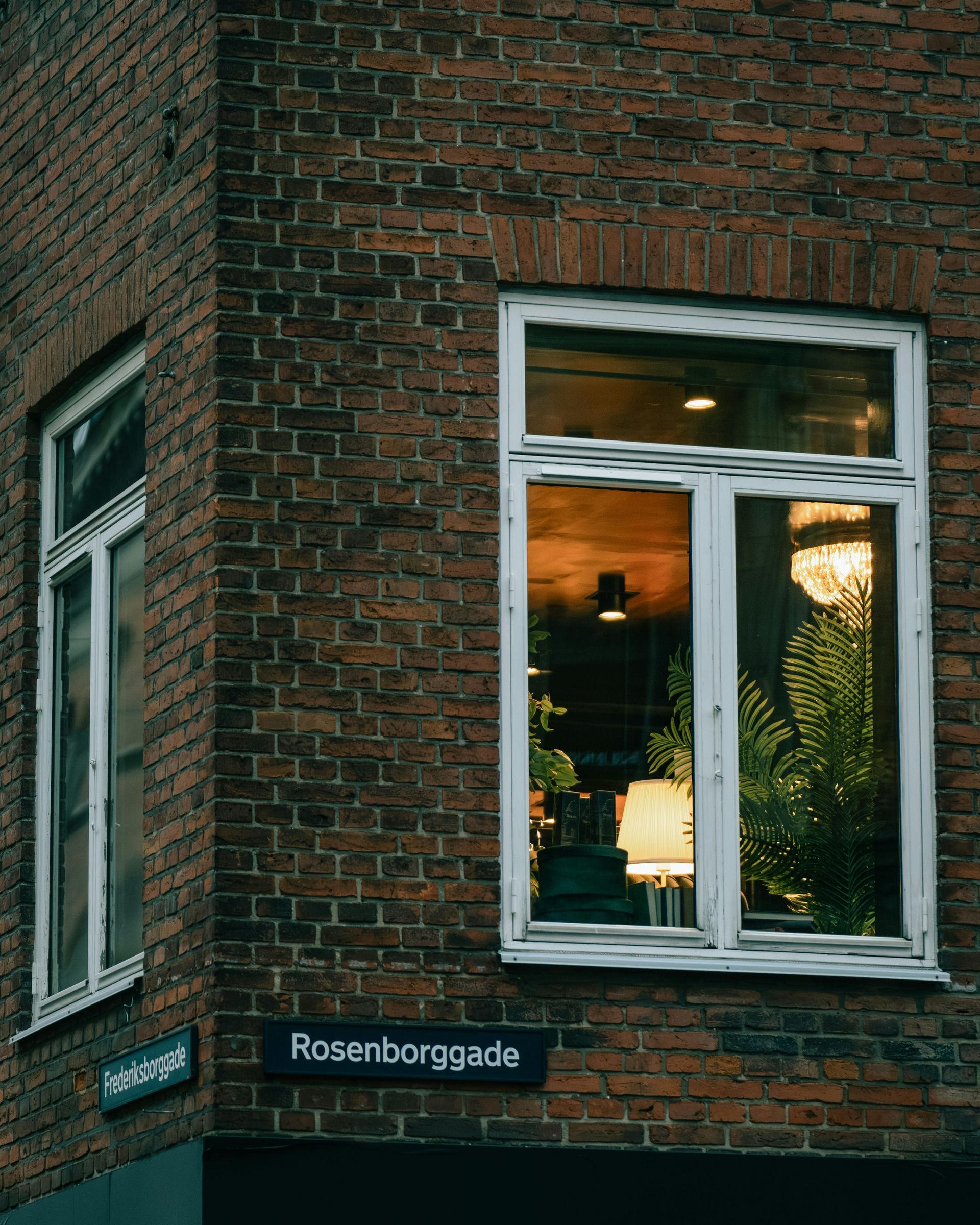 A brick building with a white window on the corner.