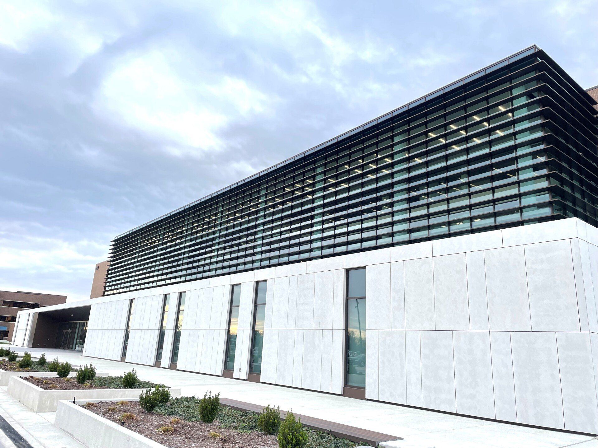 a large white building with a lot of windows on a cloudy day .