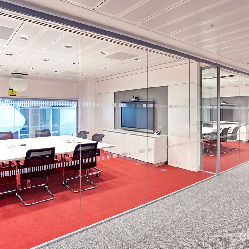 A conference room with tables and chairs and a flat screen tv