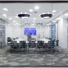 A conference room with tables and chairs behind a glass wall