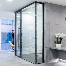 A man is standing in a room with a large glass wall.