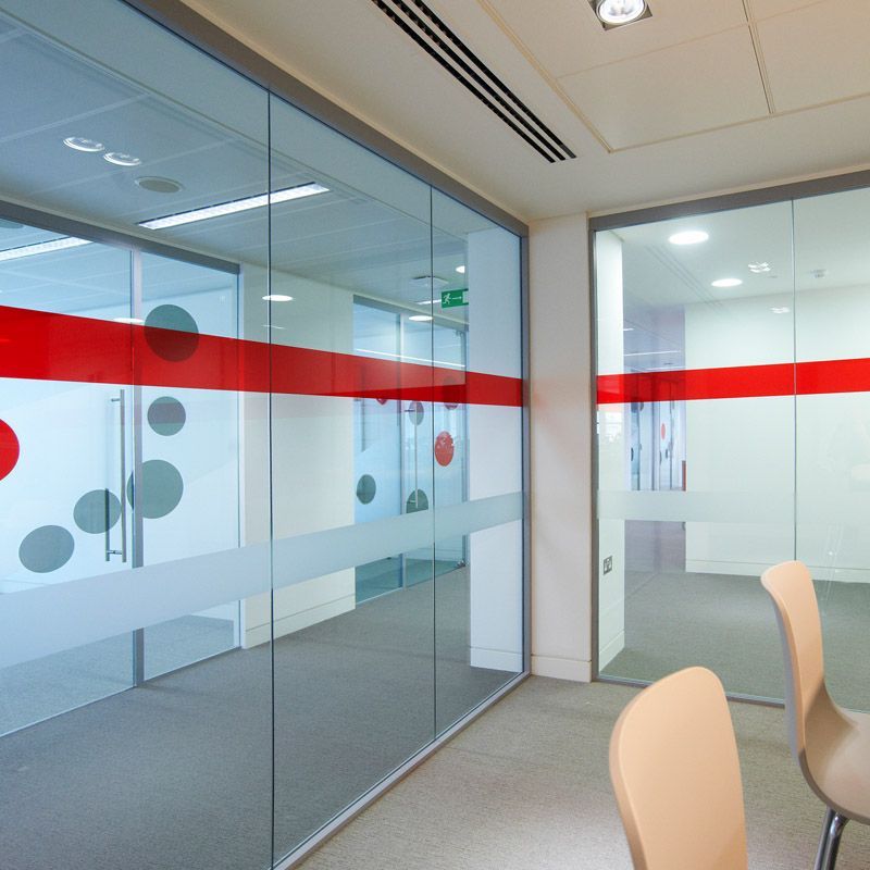 A room with a lot of glass walls and chairs