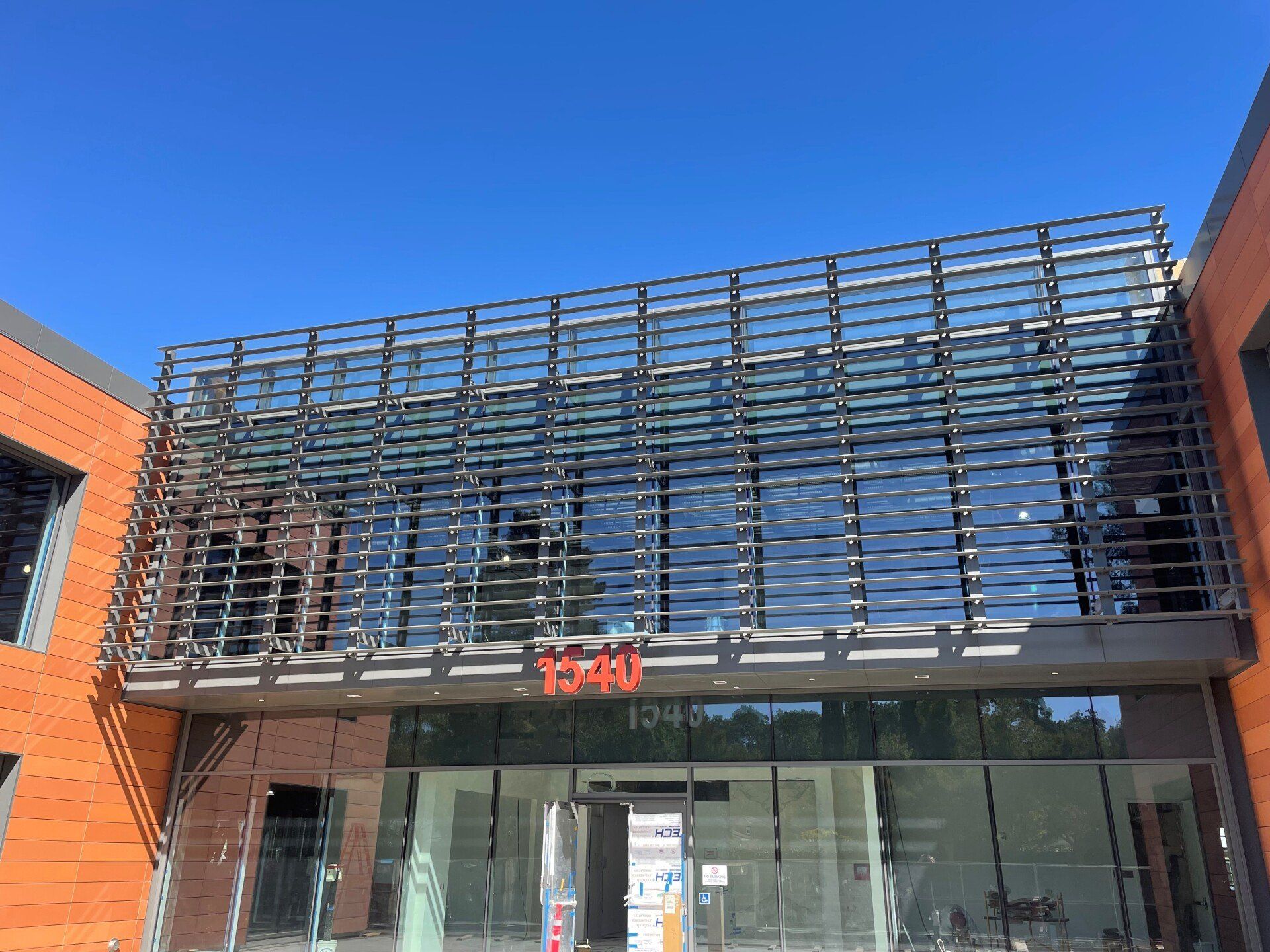 A large building with a lot of windows and a blue sky in the background.