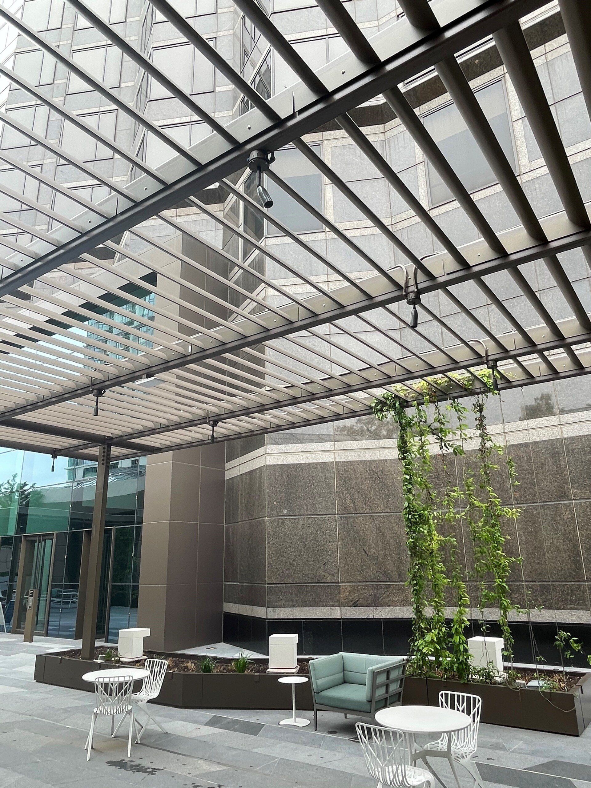 A patio with tables and chairs under a canopy