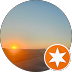 Sunset over land and sea, with an orange star icon in the corner.