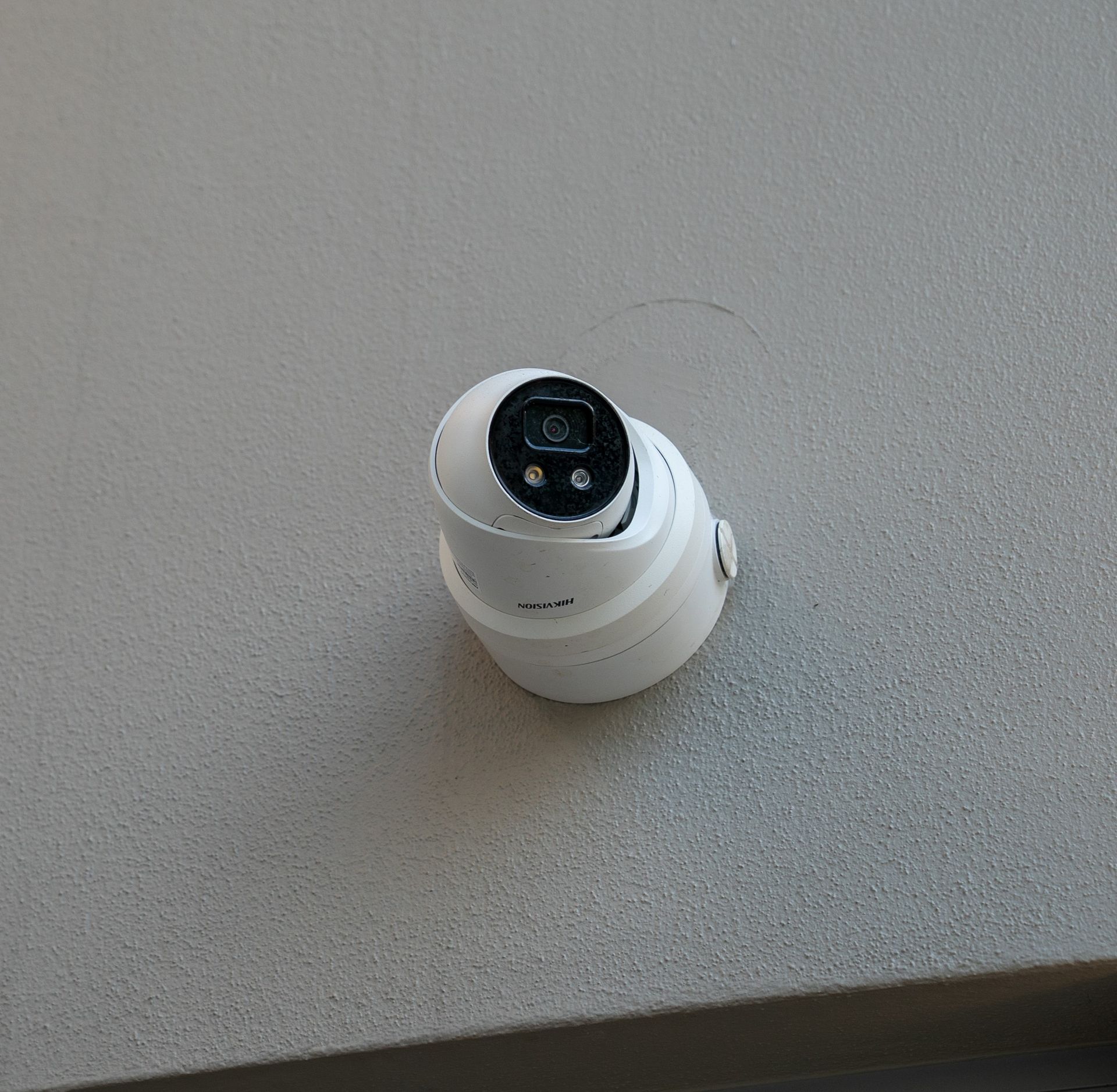 White Security Camera Mounted on a Gray Wall — Ralph Ottmann Electrical in Pomona, QLD
