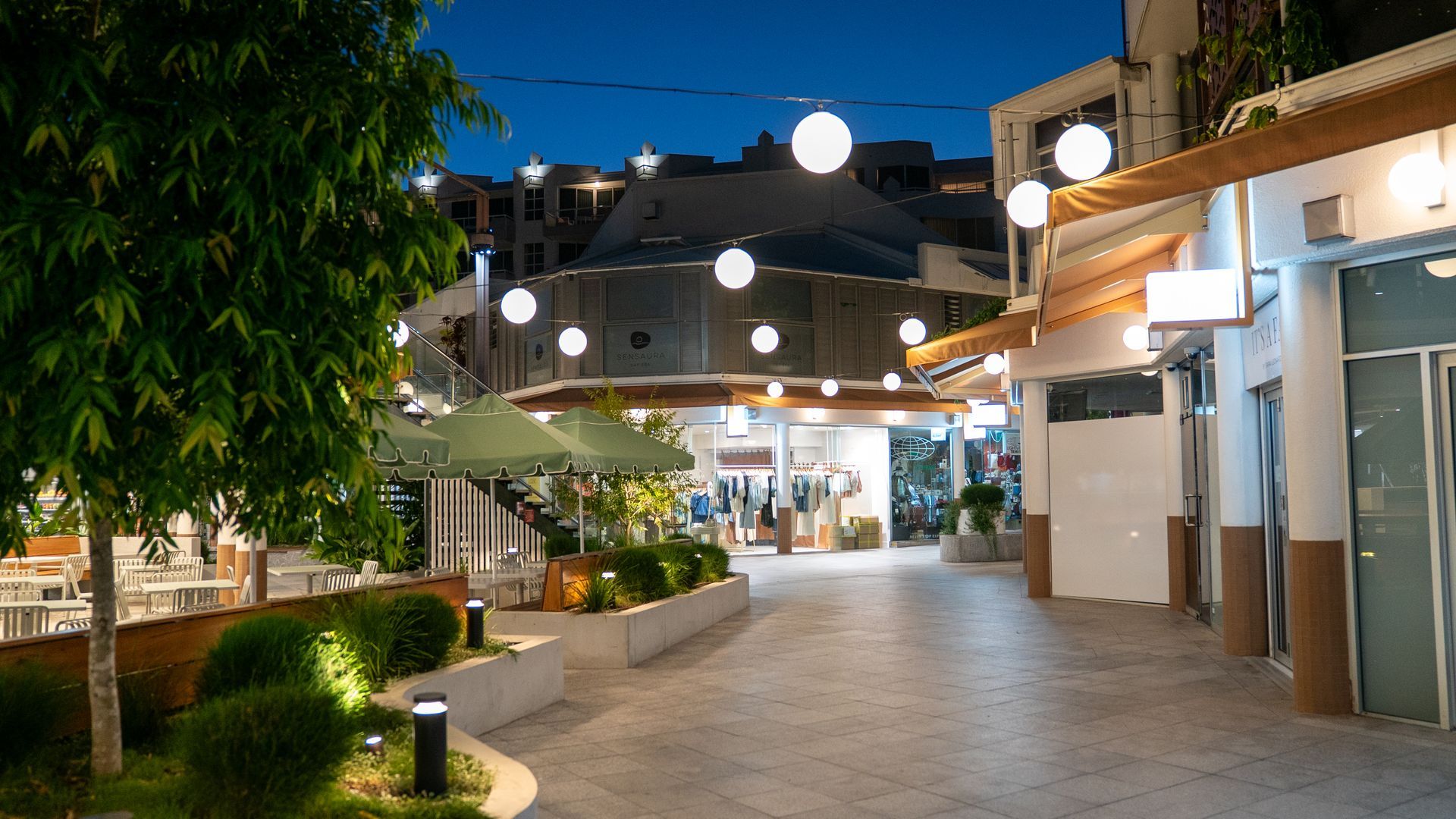 Outdoor Pedestrian Shopping Walkway With String Lights, Shops — Ralph Ottmann Electrical in Noosaville, QLD