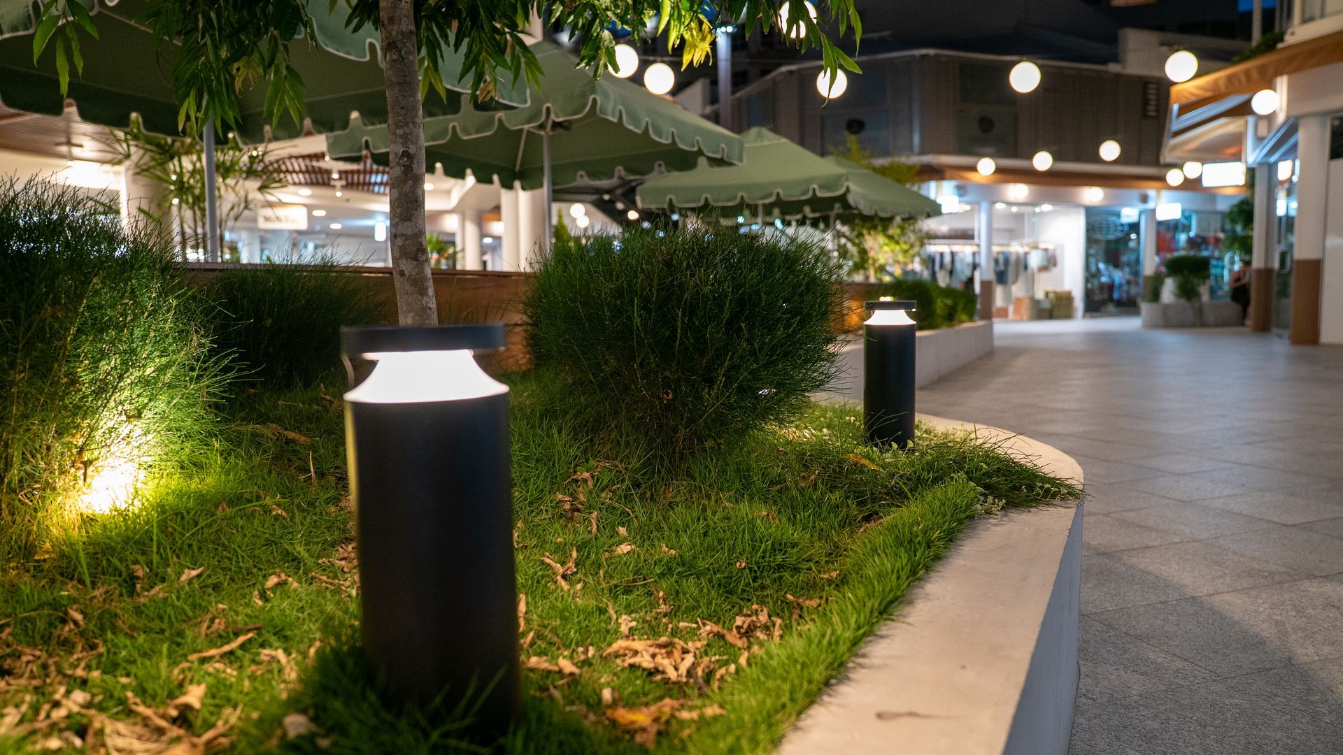 Black Bollard Lights in a Modern Outdoor Plaza at Night — Ralph Ottmann Electrical in Tewantin, QLD